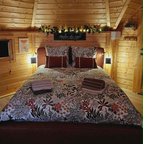 a bedroom with a large bed in a cabin at Le Clos des Chenevières in Rainville