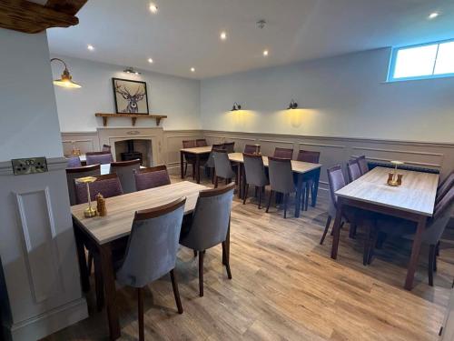 a restaurant with tables and chairs and a fireplace at The Royal George Cottingham in Cottingham