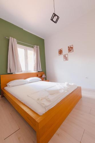 a bedroom with a wooden bed in a room at Zoumperi Summer House in Nea Makri