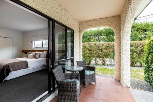 a bedroom with a bed and a table and chairs at Parkhill Lodge Villa in Hastings
