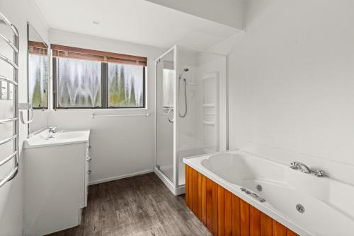 a white bathroom with a tub and a sink at Parkhill Lodge Villa in Hastings