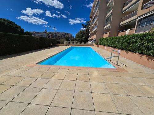 a swimming pool in front of a building at Mer et plage Standing Presta in Cannes