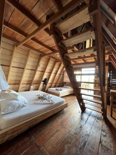 a bed in a room with a wooden ceiling at Origen ZelvaMar BahiaSolano in Bahía Solano