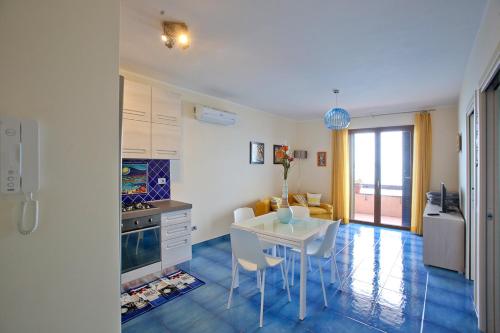 a kitchen with a table and a white table and chairs at Appartamento Valeria e Andrea in Porto Santo Stefano