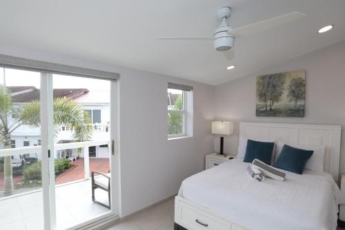 a white bedroom with a bed and a window at 232C South Finger in Jolly Harbour
