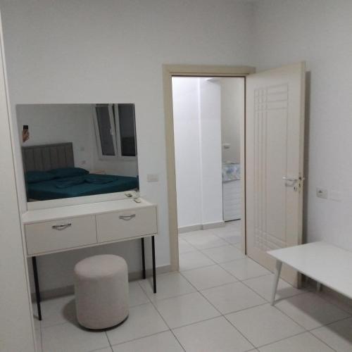 a room with a mirror and a dresser with a bed at Private Rooms in Velipojë