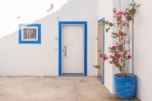 a blue door and a plant in a blue vase at B&B di MARE in Orta Nova