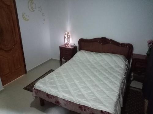 a bedroom with a bed and a lamp on a table at F2 bien situe in Oran