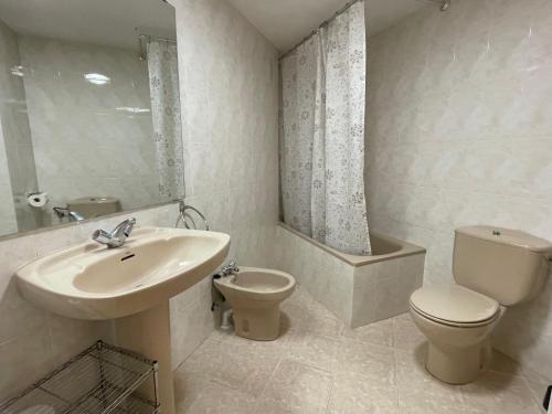 a white bathroom with a sink and a toilet at Tena Biescas Tourist Home in Biescas