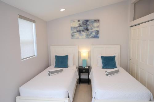 two beds with blue pillows in a room at 232D South Finger in Jolly Harbour