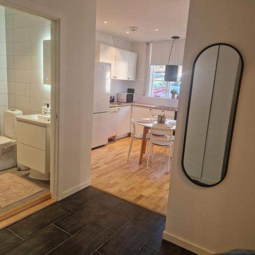 a kitchen and dining room with a table and a mirror at Central City Apartment B in Nyköping