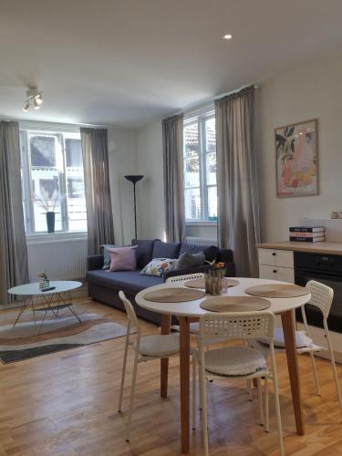 a living room with a couch and a table and chairs at Central City Apartment B in Nyköping