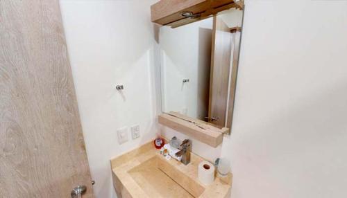 a bathroom with a sink and a mirror at Hotel la Cuesta Toscana in Bernal