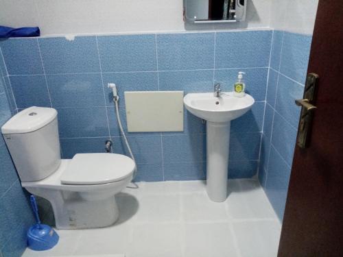 a blue tiled bathroom with a toilet and a sink at F2 bien situe in Oran