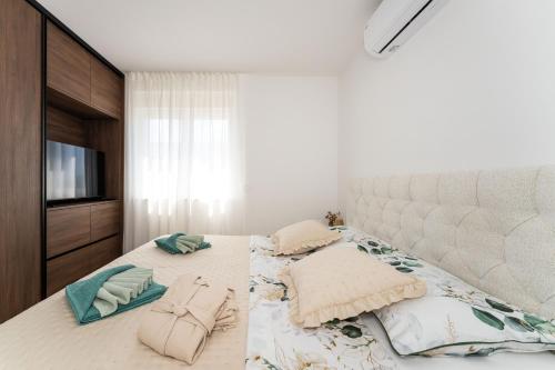 a bedroom with a bed with two pillows and a television at Sky Lounge & More - Rooftop Wellness & Gym in Zadar