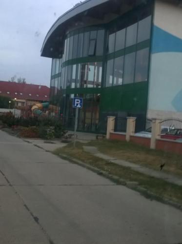 a building with a parking sign in front of it at Horváth Apartman in Cserkeszőlő