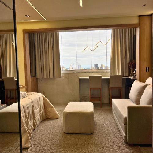 ein Krankenzimmer mit einem Bett, einem Tisch und einem Fenster in der Unterkunft Royale Studio in Criciúma