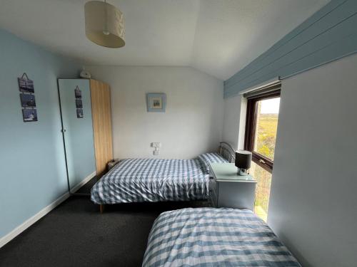 two beds in a small room with a window at 39 Perran View Your Home Away from Home in Cornwall in St. Agnes