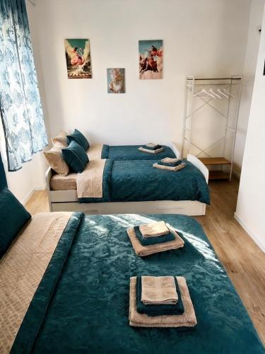 two beds in a room with towels on the floor at Sea Breeze Suites in Livorno