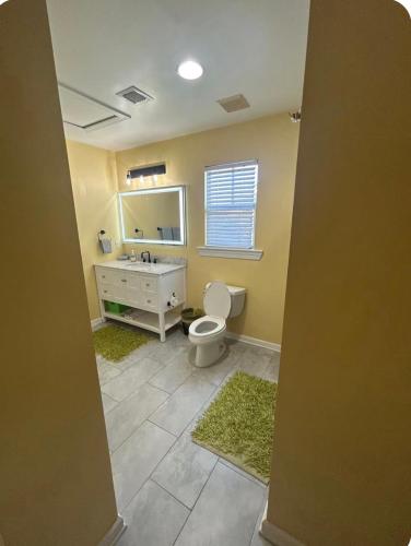 a bathroom with a toilet and a sink and a mirror at Charming Key West Rental in Key West