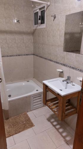 a bathroom with a tub and a sink and a bath tub at Apart Hotel Costanera Colon in Colón