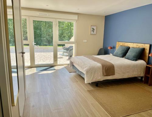 a bedroom with a large bed with blue walls at Domaine de la Brême in Bréménil
