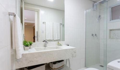 a white bathroom with a sink and a shower at Casa da Ópera in Diamantina