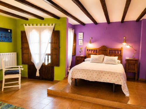 a bedroom with purple and green walls and a bed at Apartamentos La Iguana in Hervás