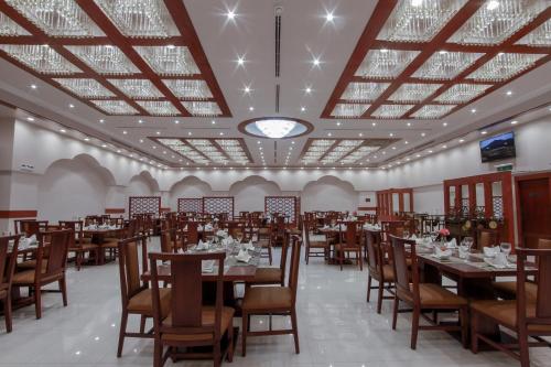 a dining room with tables and chairs and a ceiling at Marsa Diba Hotel in Ḑubā