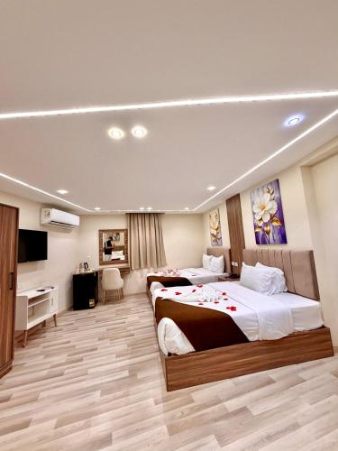 a hotel room with two beds and a television at Sunshine Pyramids Hotel & Restaurant in Cairo