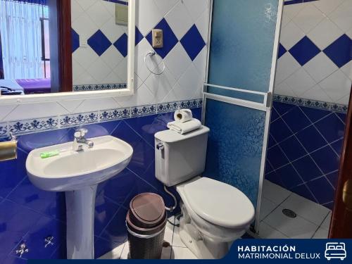 a blue and white bathroom with a toilet and a sink at Hotel Diamante Azul in La Paz