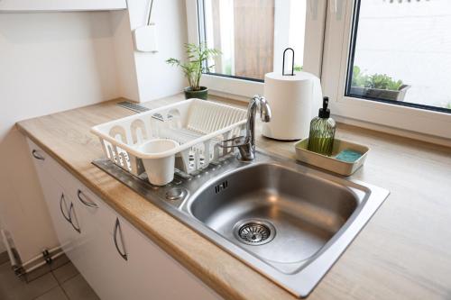 a kitchen sink with a dish drying rack on it at Domek w Starym Mieście in Stare Miasto