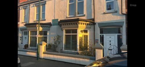 a building with windows and a white door on a street at Abbey GH All Rooms En-Suite in Redcar