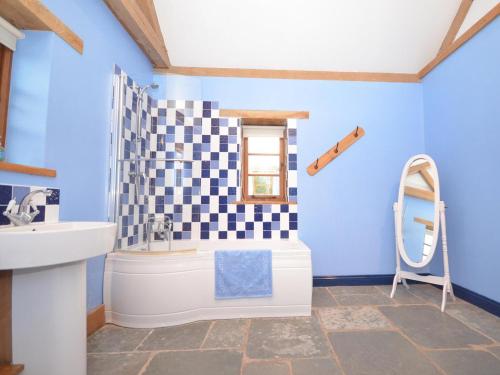 a bathroom with blue walls and a sink and a tub at 1 Bed in Somerton oc-asher in Compton Dando
