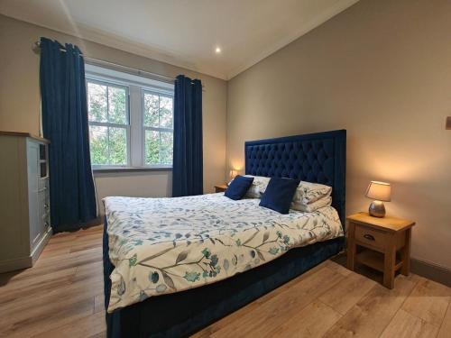 a bedroom with a large bed with blue curtains at 1 Bed in Duns oc-83140 in Duns