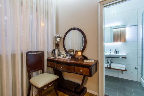 La salle de bains est pourvue d'une coiffeuse, d'un miroir et d'une chaise. dans l'établissement Scallop Regent Rooms, à Zadar