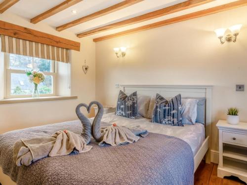 two swans sitting on a bed in a bedroom at 2 Bed in Belper oc-74965 in Crich
