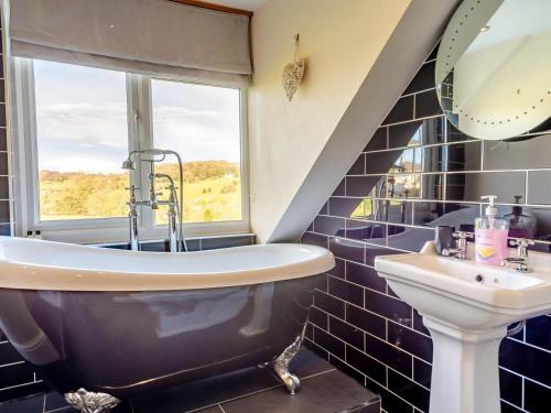 a blue tiled bathroom with a tub and a sink at 2 Bed in Belper oc-74965 in Crich