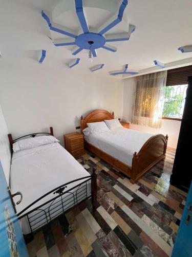 a bedroom with two beds and a ceiling fan at Casa Barkouk Central Chefchaouen Apartment in Chefchaouen