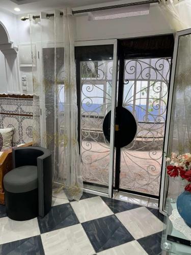 a room with a chair and a glass door at Casa Barkouk Central Chefchaouen Apartment in Chefchaouen