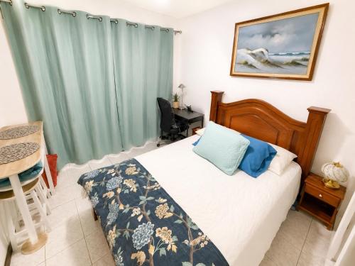 a bedroom with a bed and a desk and a table at Alojamiento Cereza 2 in Alajuela