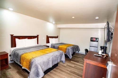 a hotel room with two beds and a television at Indian Mound Motel in Fairmont City