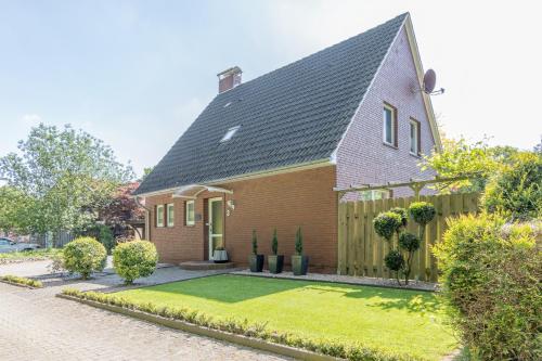 a brick house with a fence and a yard at Lieblingsplatz in Lathen