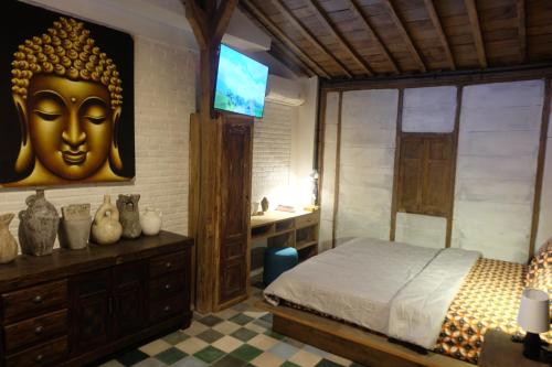 a bedroom with a bed with a large gold head on the wall at Jagadhita Villas in Sekatonan