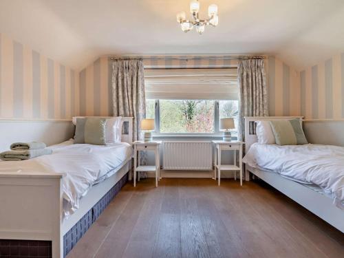 two beds in a room with a window at 3 Bed in Brockenhurst oc-nfl92 in Brockenhurst
