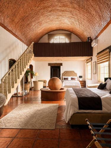 a bedroom with a large bed and a staircase at Suite Copal in Tecozautla