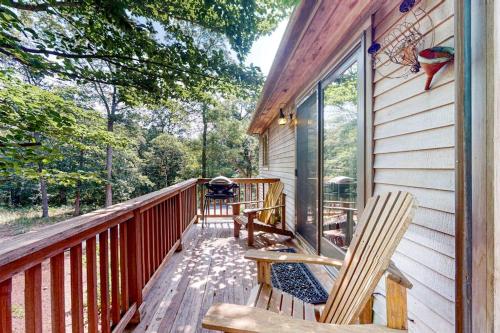 a porch of a cabin with two chairs and a grill at Nana's Rear Treehouse in West Tisbury