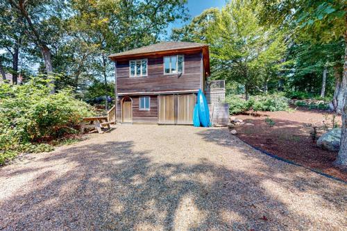 a small wooden house in the middle of a yard at Nana's Rear Treehouse in West Tisbury
