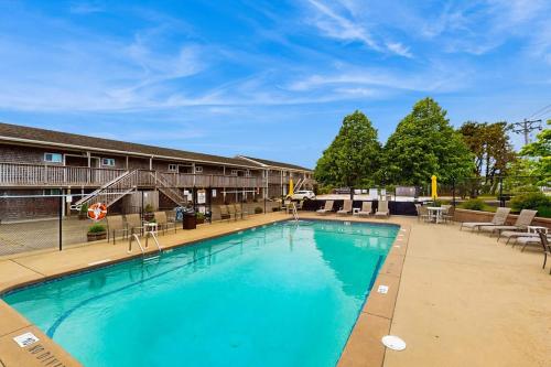 a large swimming pool with chairs and a building at Large Studio with Patio and Pool in North Truro