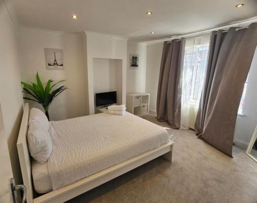 a bedroom with a white bed and a window at Mirandas Place in Gillingham